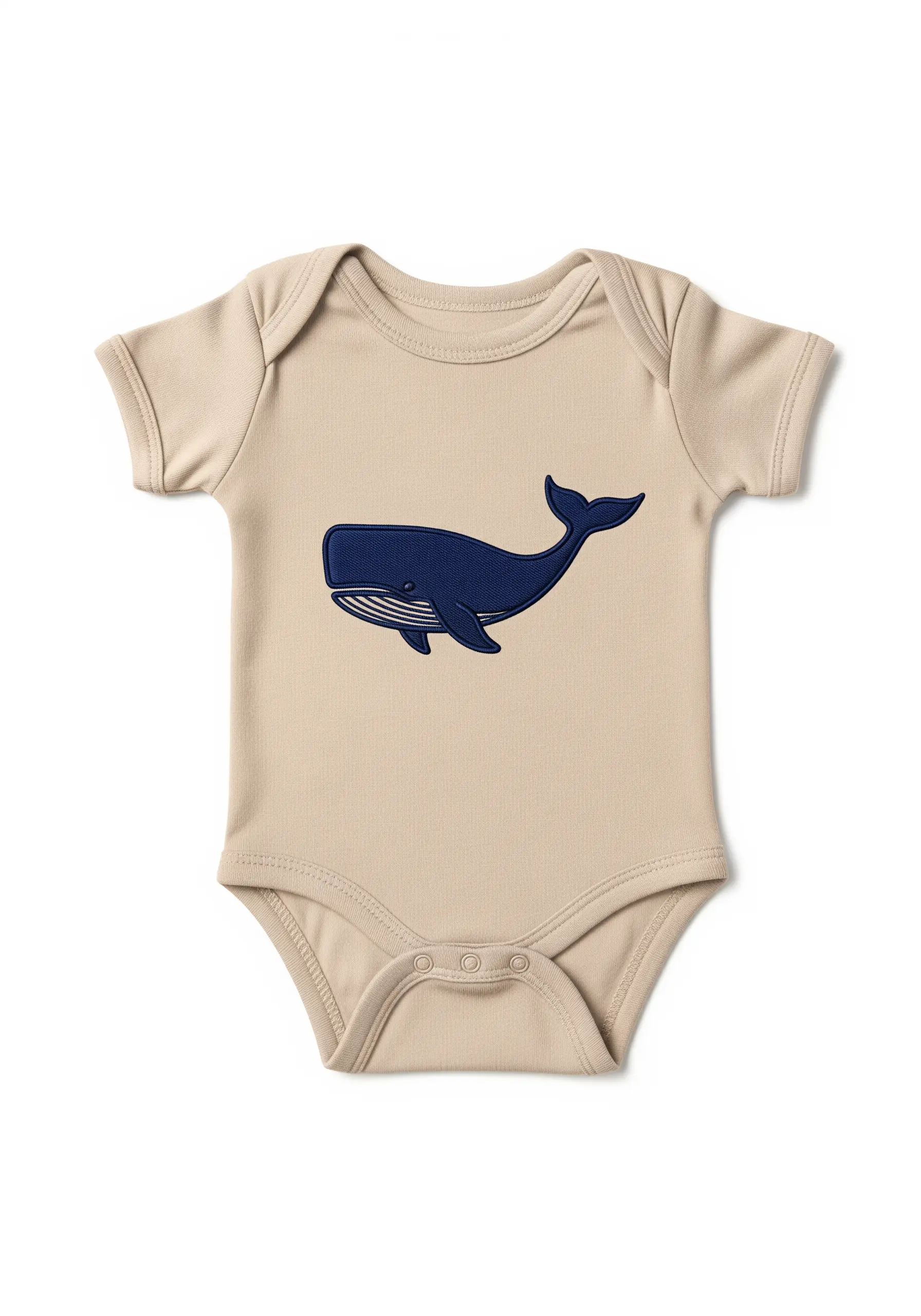 A bold, navy blue embroidered whale with a smooth satin stitch on a beige bodysuit.