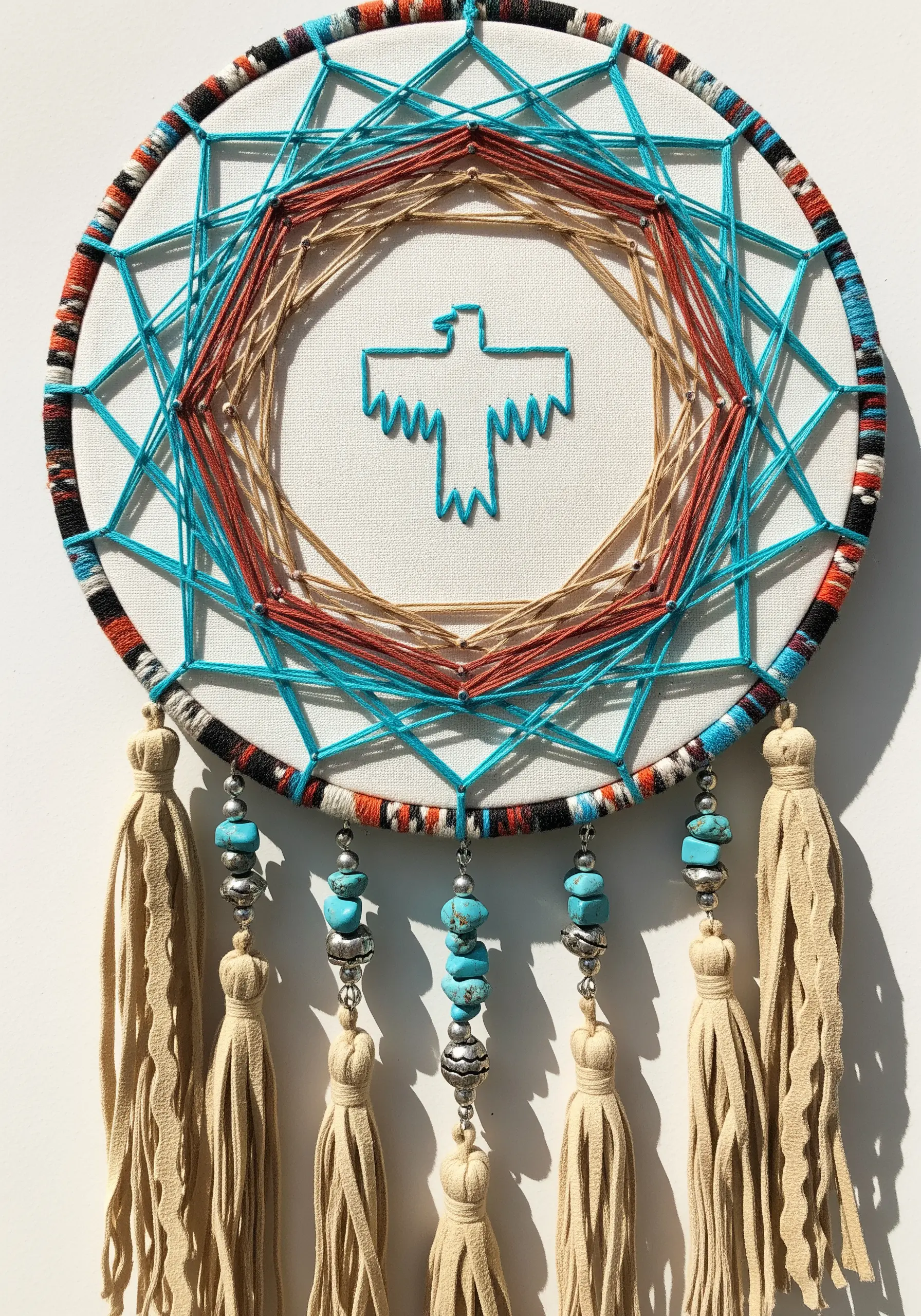 Southwestern-style dreamcatcher with a thunderbird motif and turquoise beads.