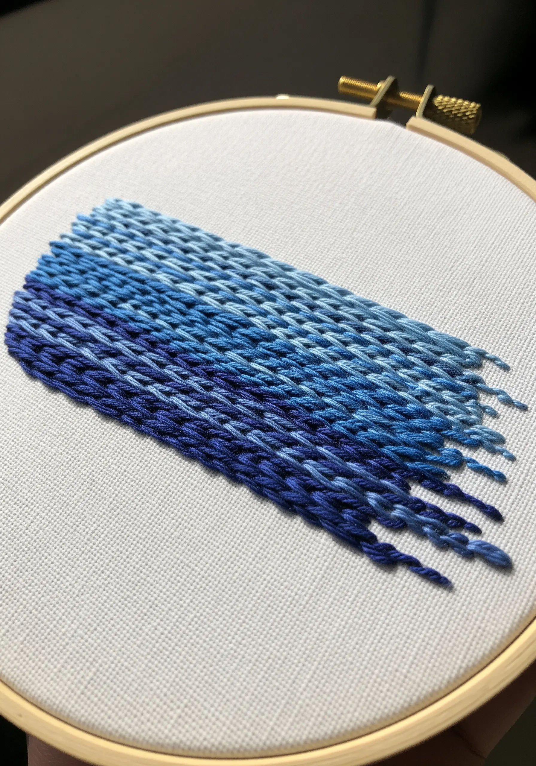 Abstract woven patch of chain stitches in shades of blue, creating a gradient.