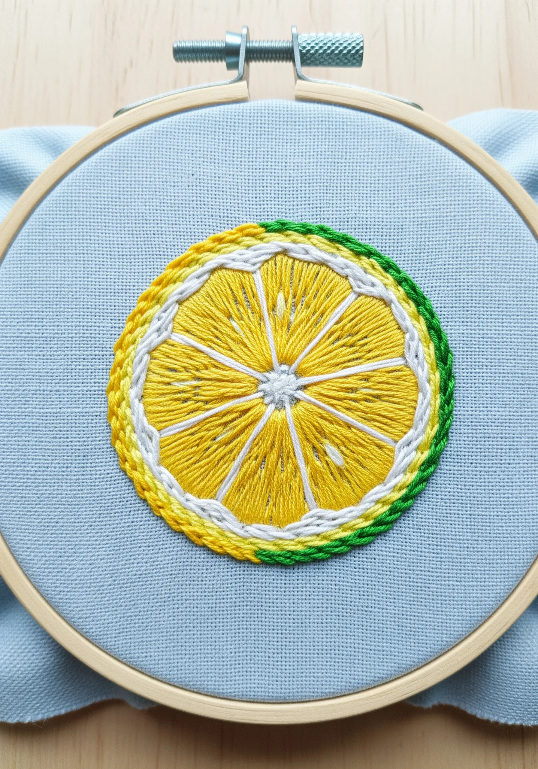 Embroidered lemon slice with detailed segments and a multi-colored rind.