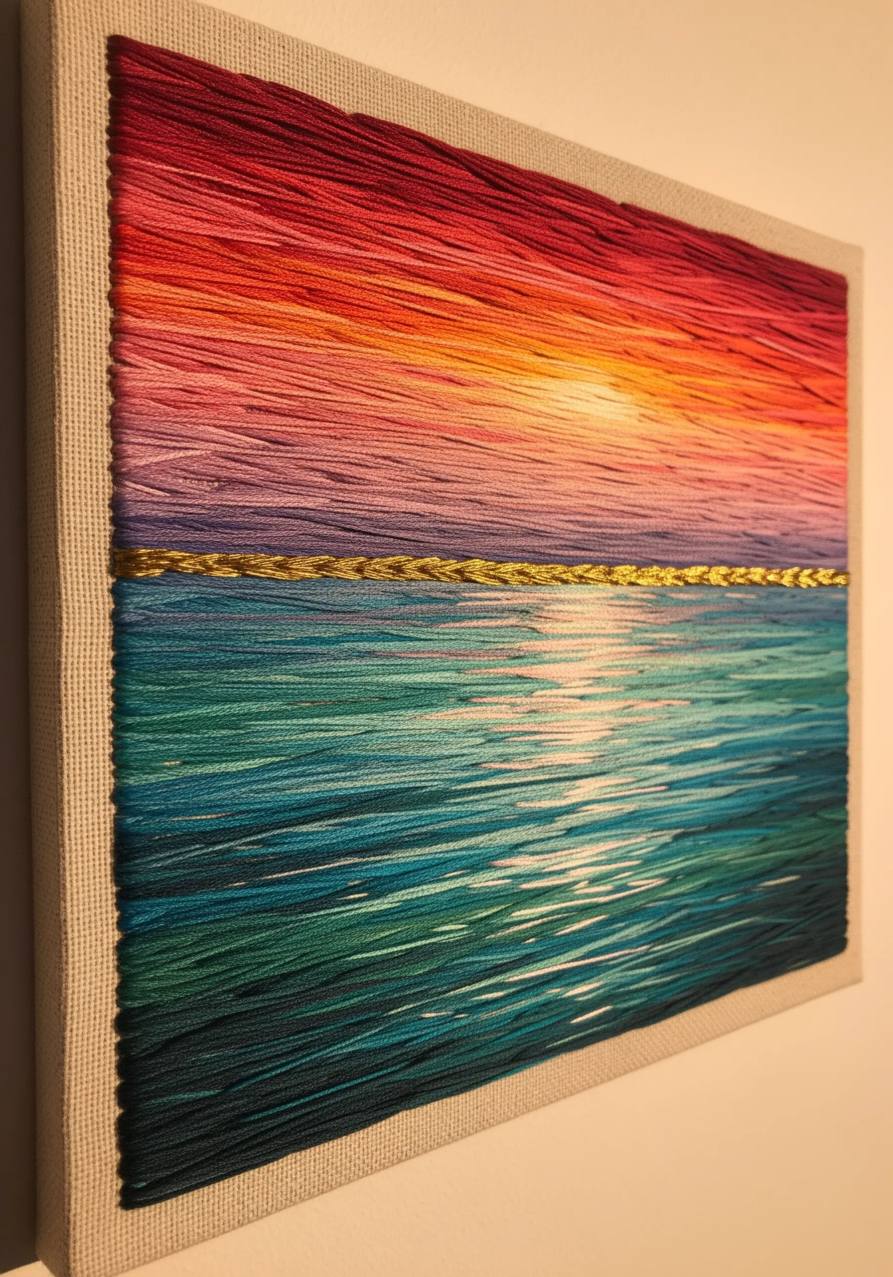 Abstract sunset seascape with horizontal satin stitches and a gold thread horizon line.