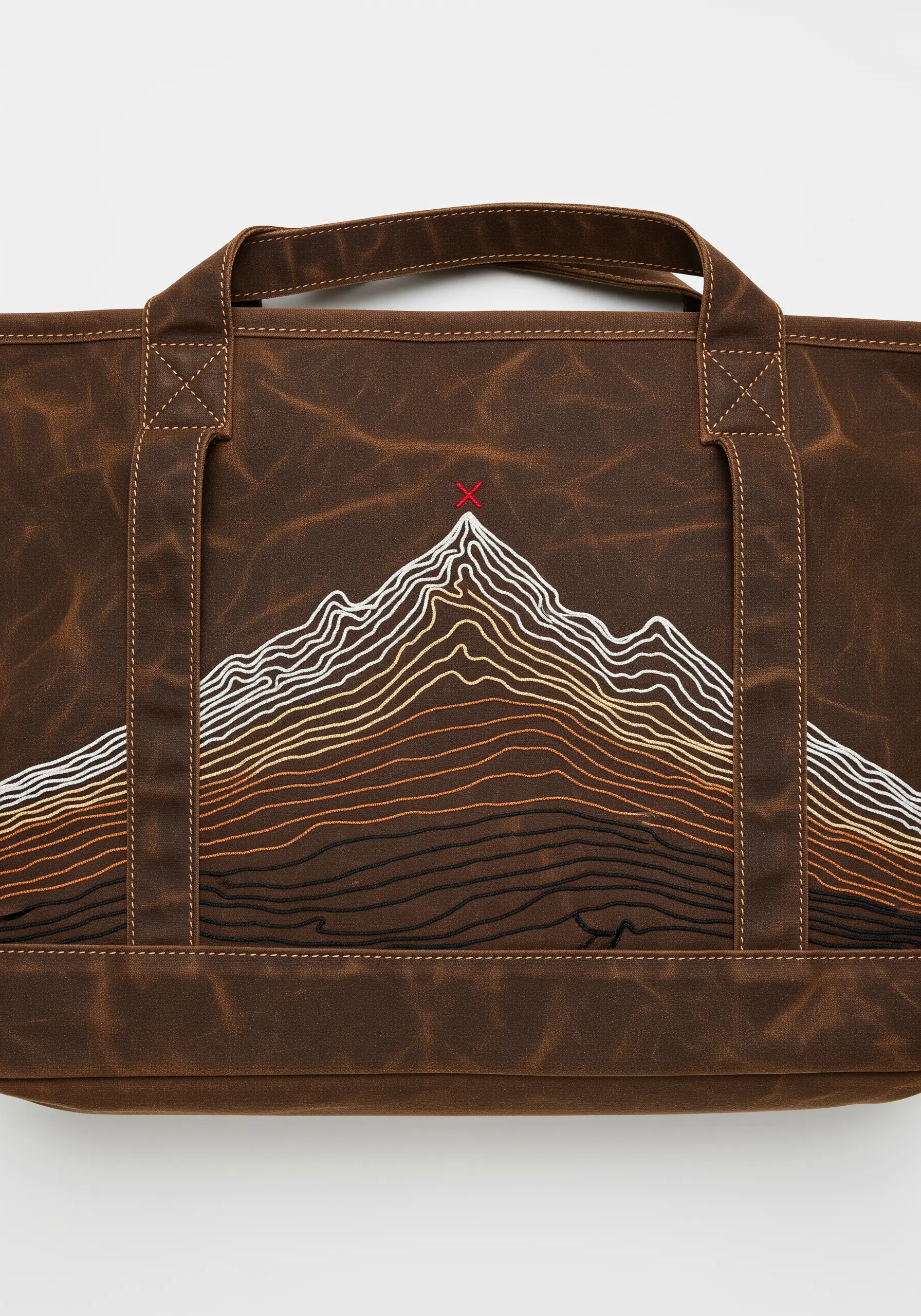 A topographic map of a mountain embroidered in gradient thread on a brown waxed canvas bag.