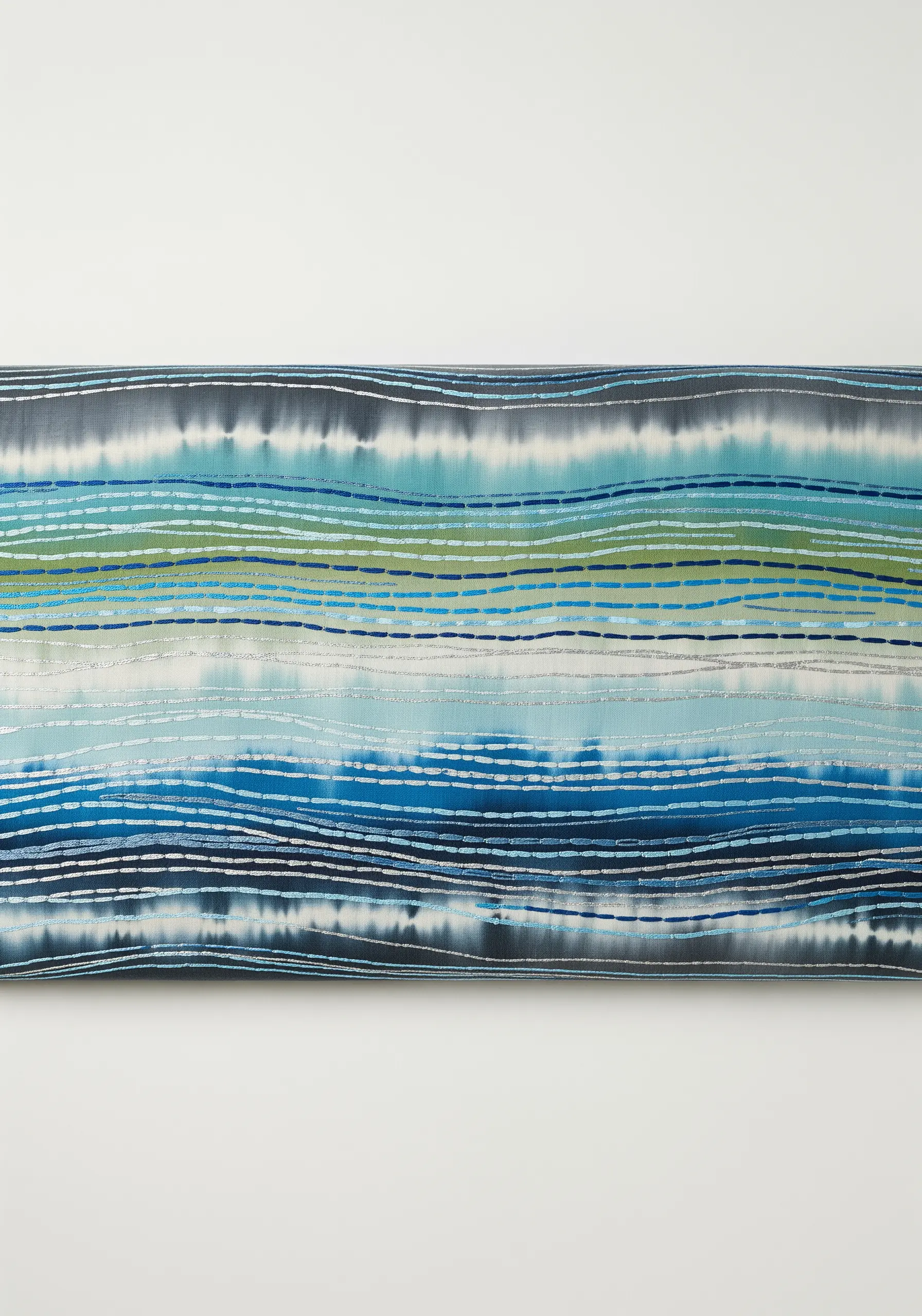 Watercolor-effect fabric with horizontal lines of silver metallic running stitch tracing the colors.