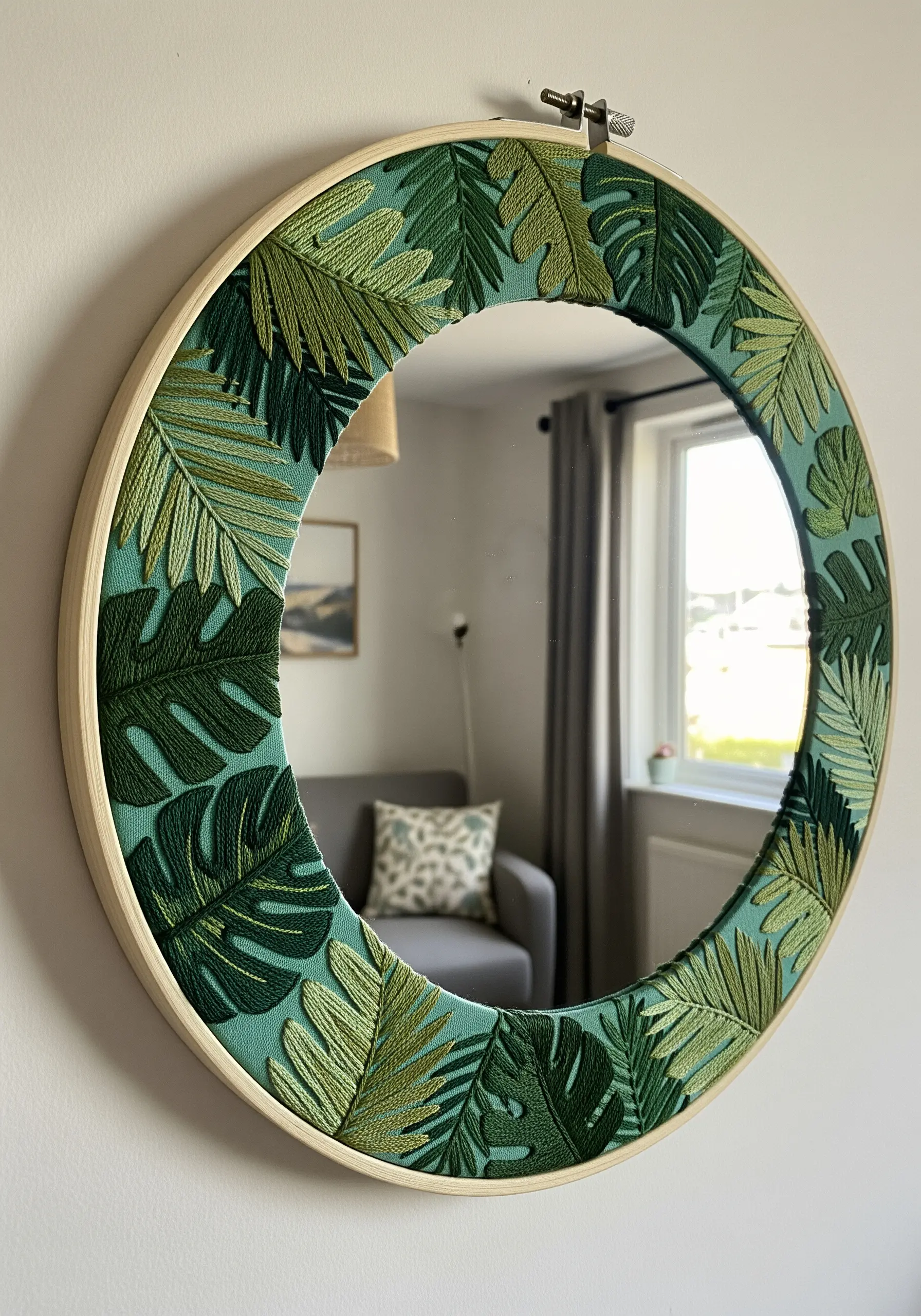 Round mirror with embroidered tropical leaf frame