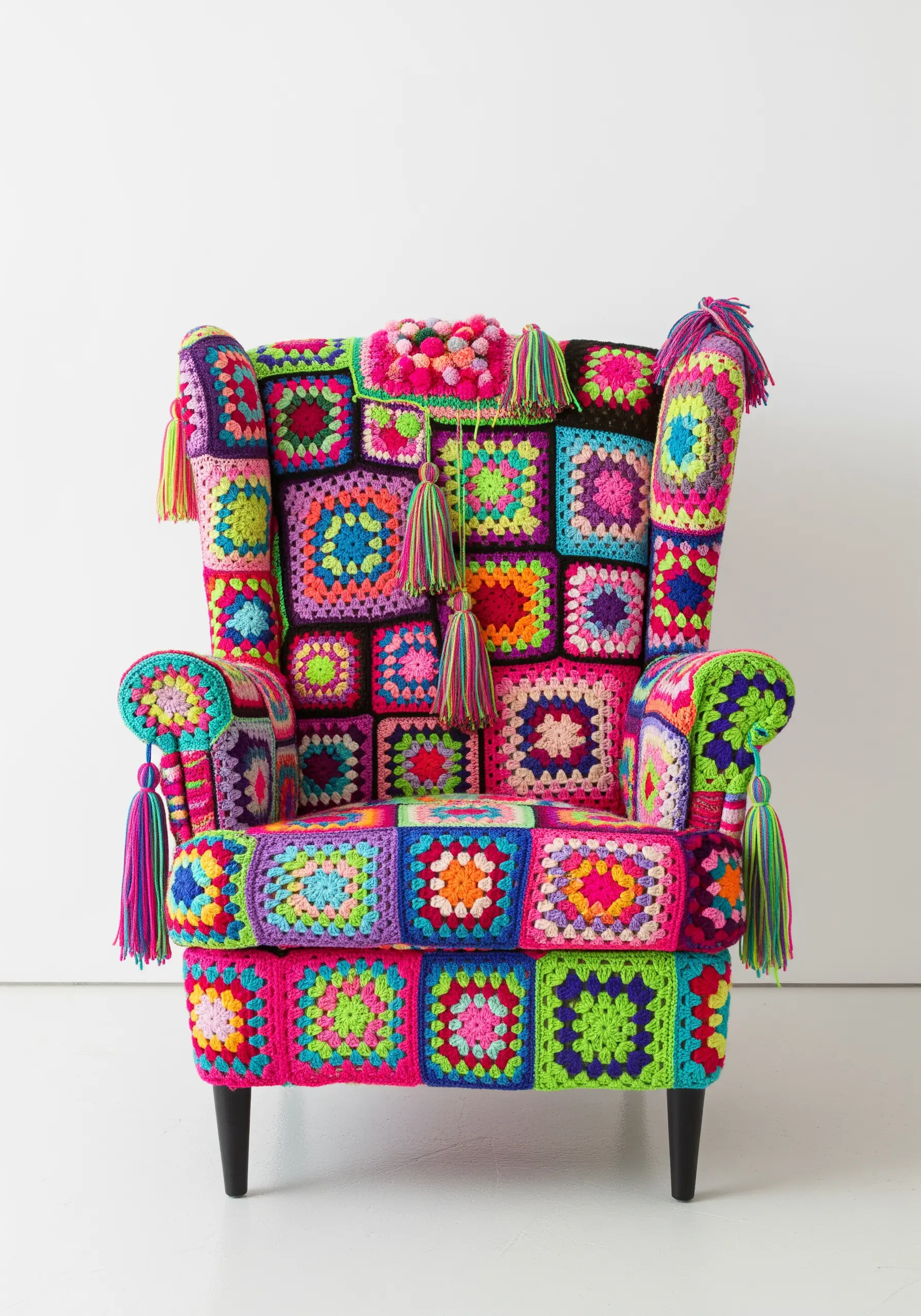 An armchair completely covered in a patchwork of vibrant, multi-colored crocheted granny squares.