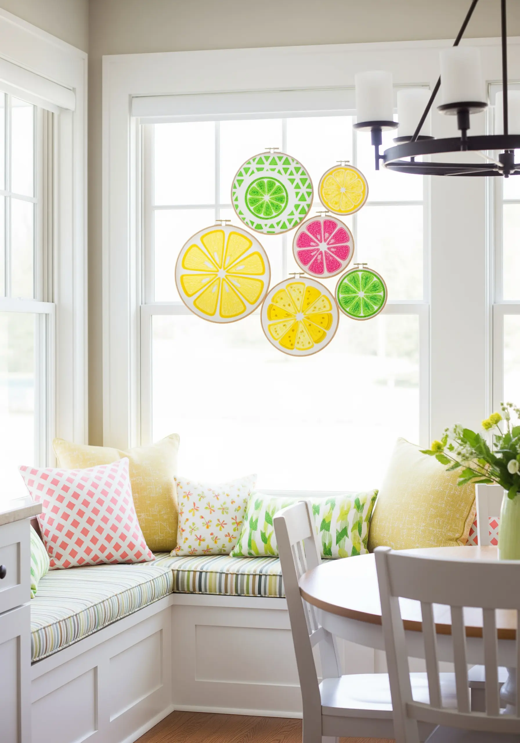 Embroidered citrus slices on transparent fabric hanging in a window.