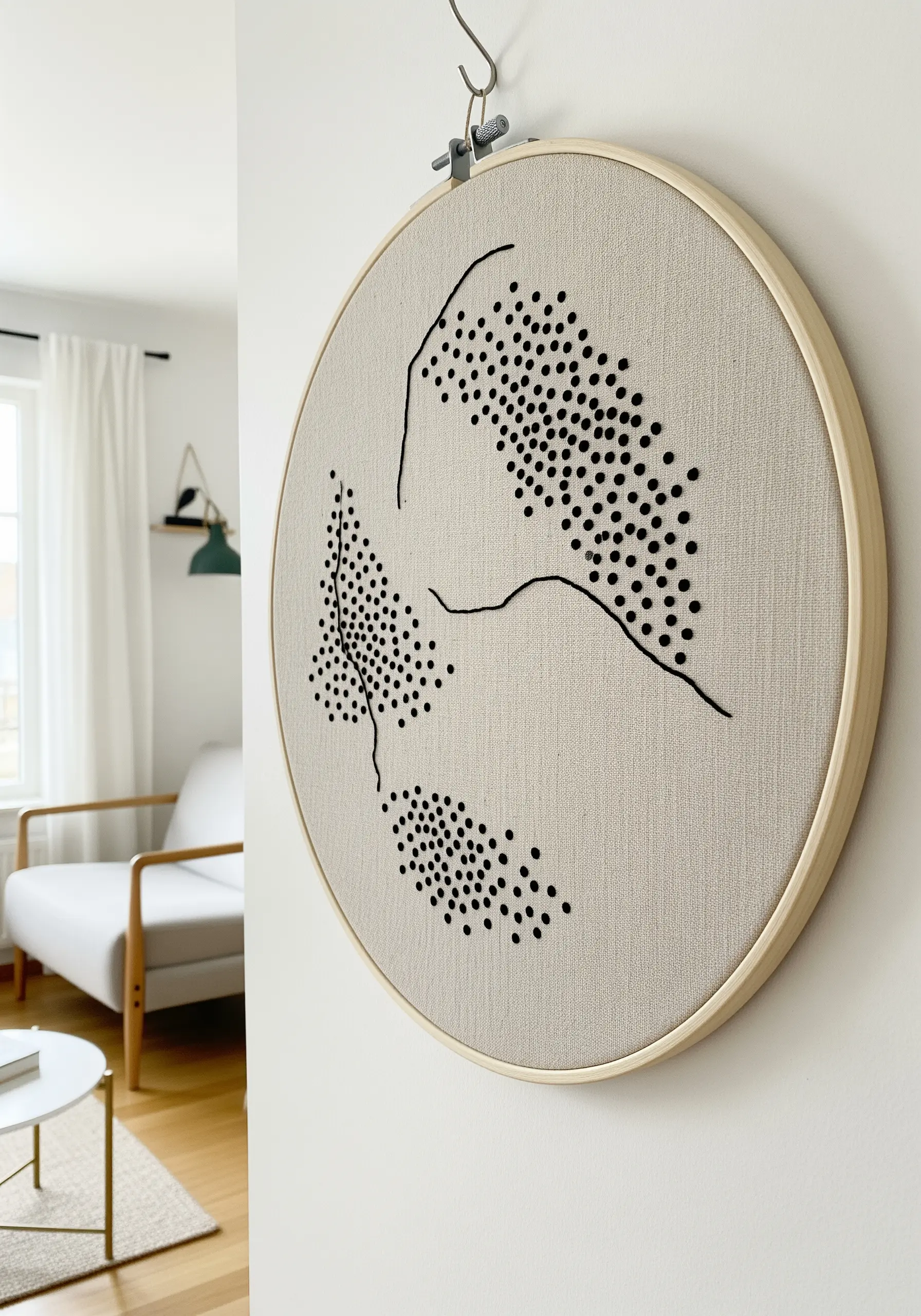 Abstract shapes created with hundreds of black French knots on neutral fabric.