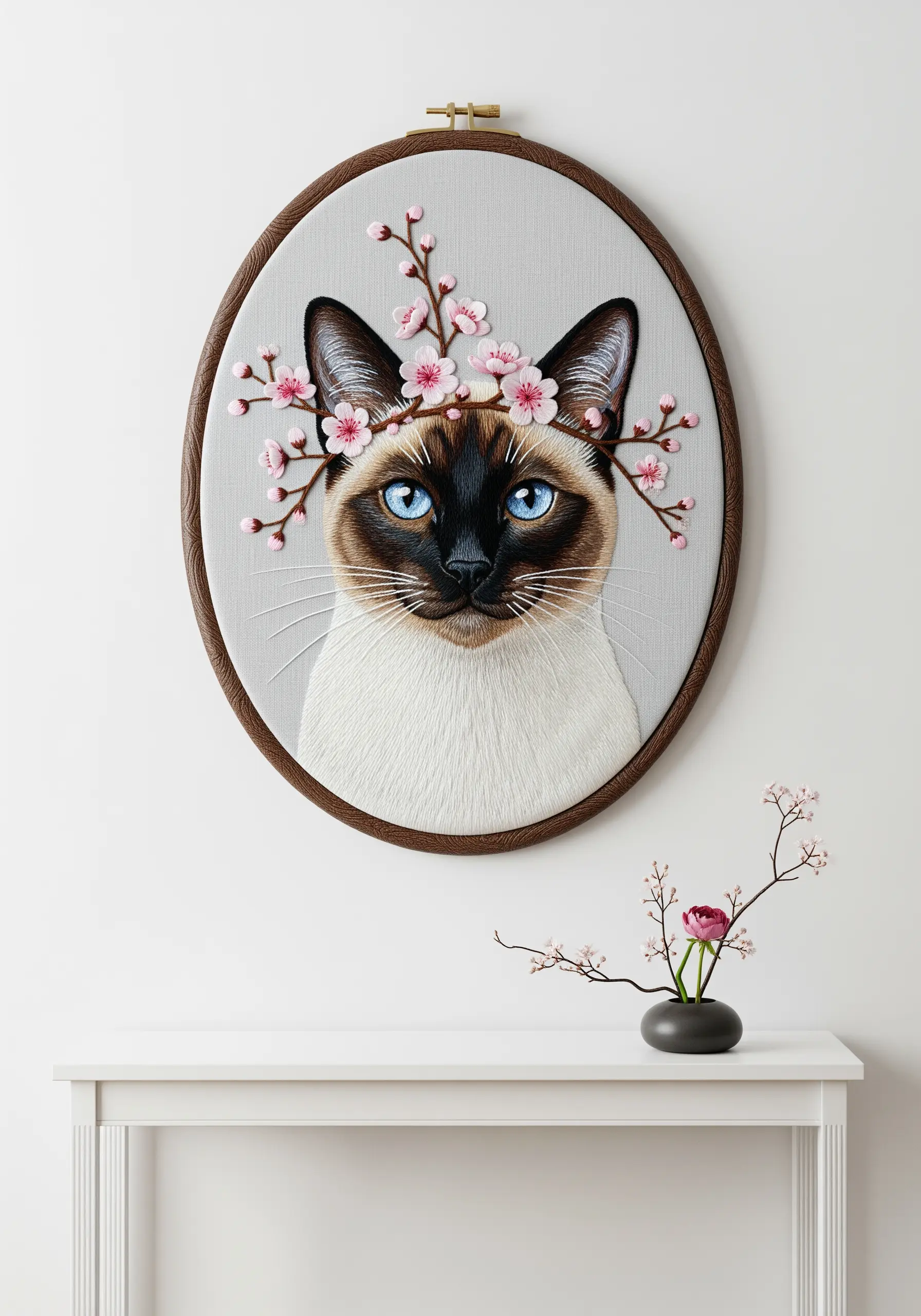 Realistic embroidery of a Siamese cat with blue eyes and a pink cherry blossom crown.