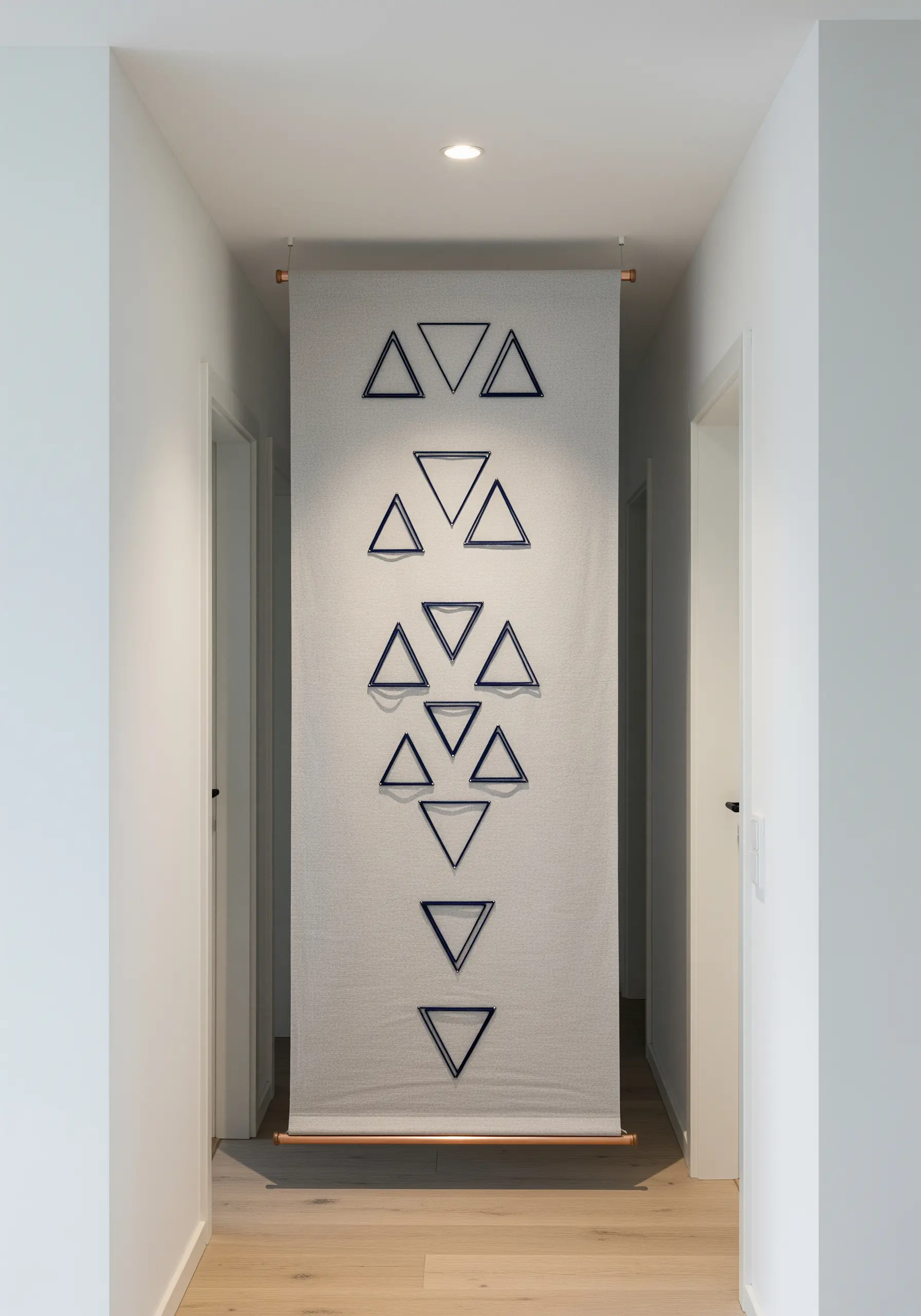 A long hallway banner with a vertical column of embroidered dark blue triangles.