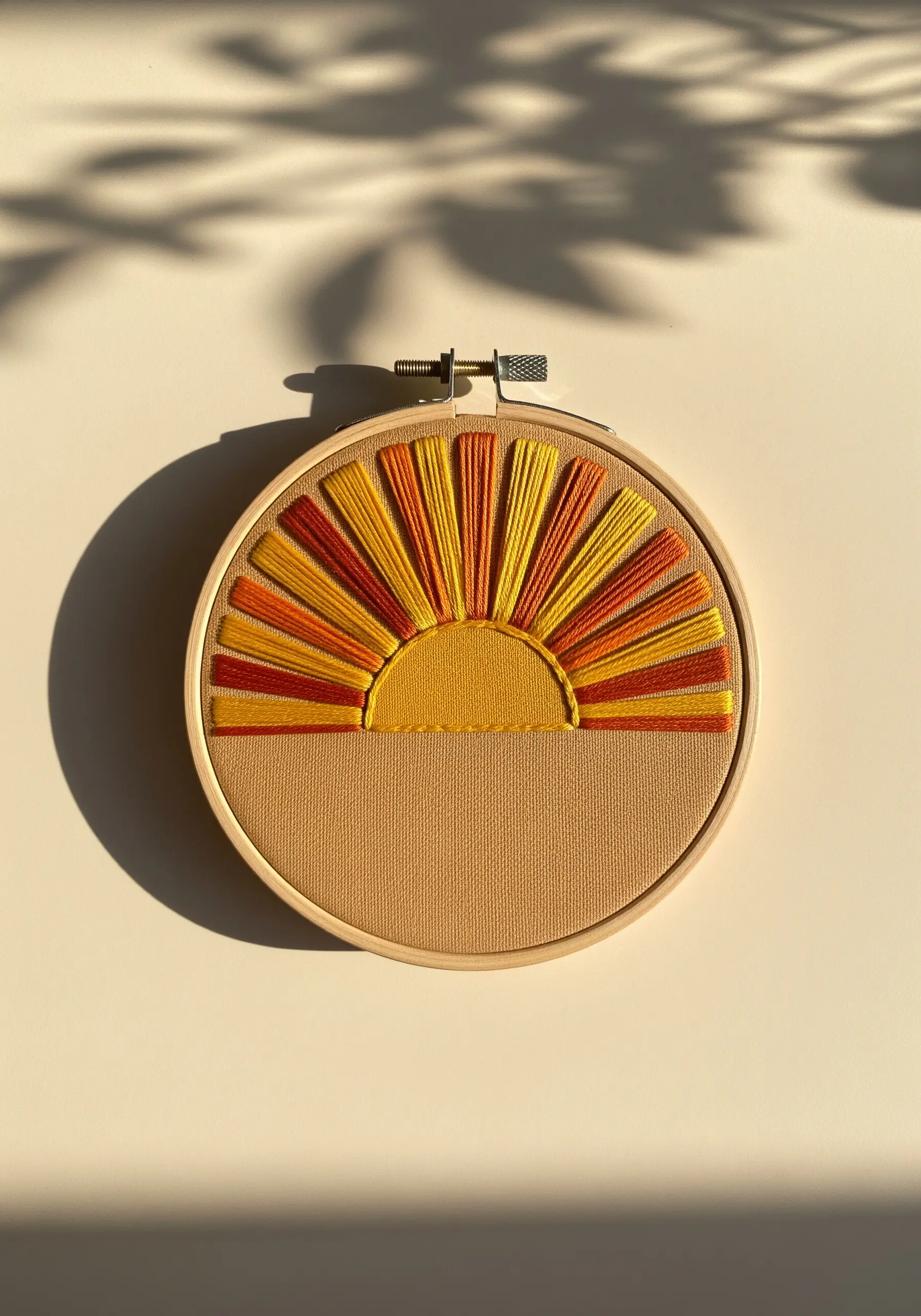 Abstract sunset embroidery with warm yellow and orange satin stitch rays
