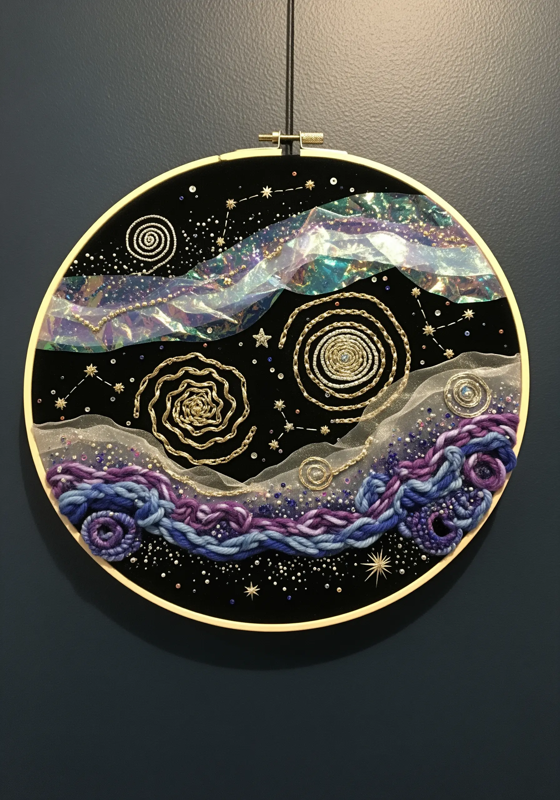 Celestial embroidery on black velvet with couched gold spirals, iridescent film, and purple yarn.