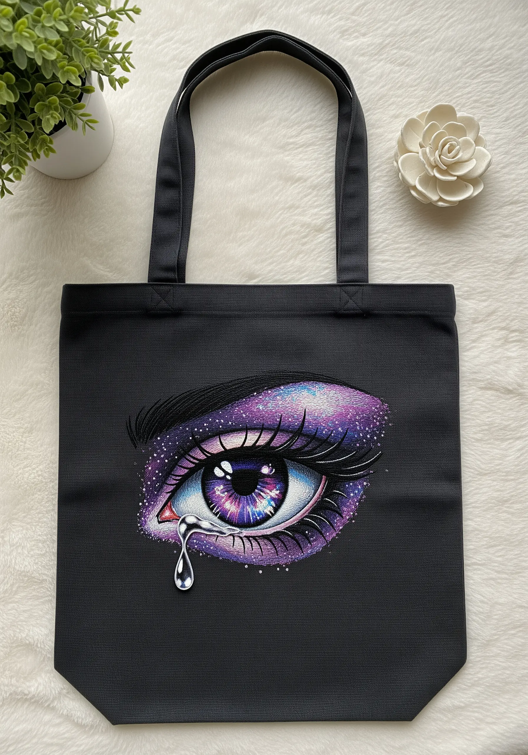 A hyper-detailed embroidered eye with a purple and blue galaxy nebula in the iris.