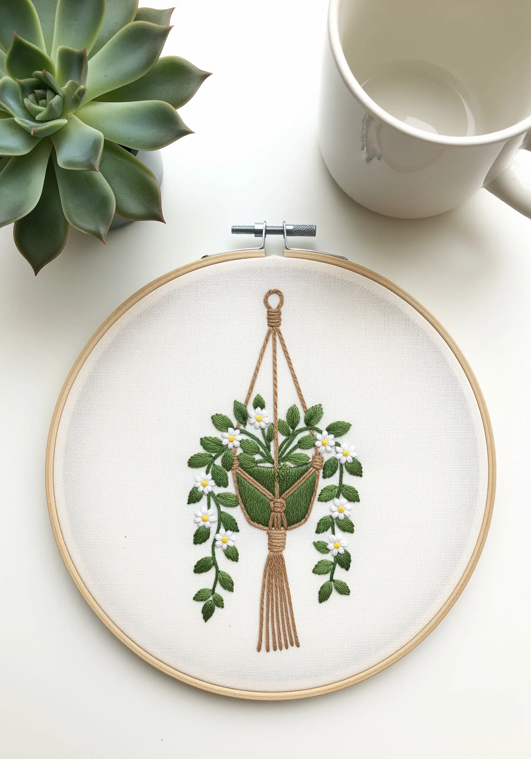 Embroidered hanging planter with knotted stitches for the macrame and tiny flowers.