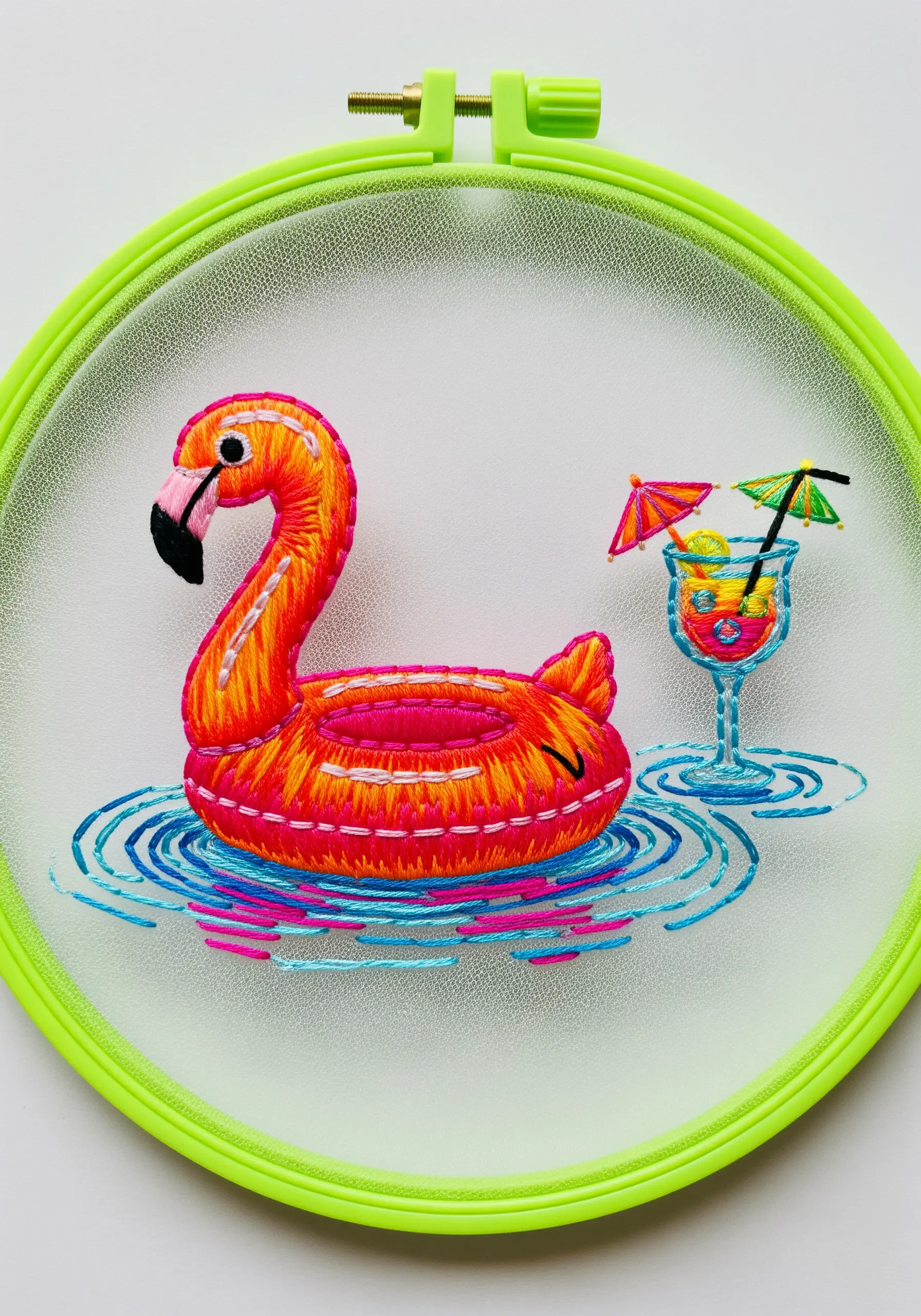 Embroidery of a flamingo pool float and cocktail on mesh