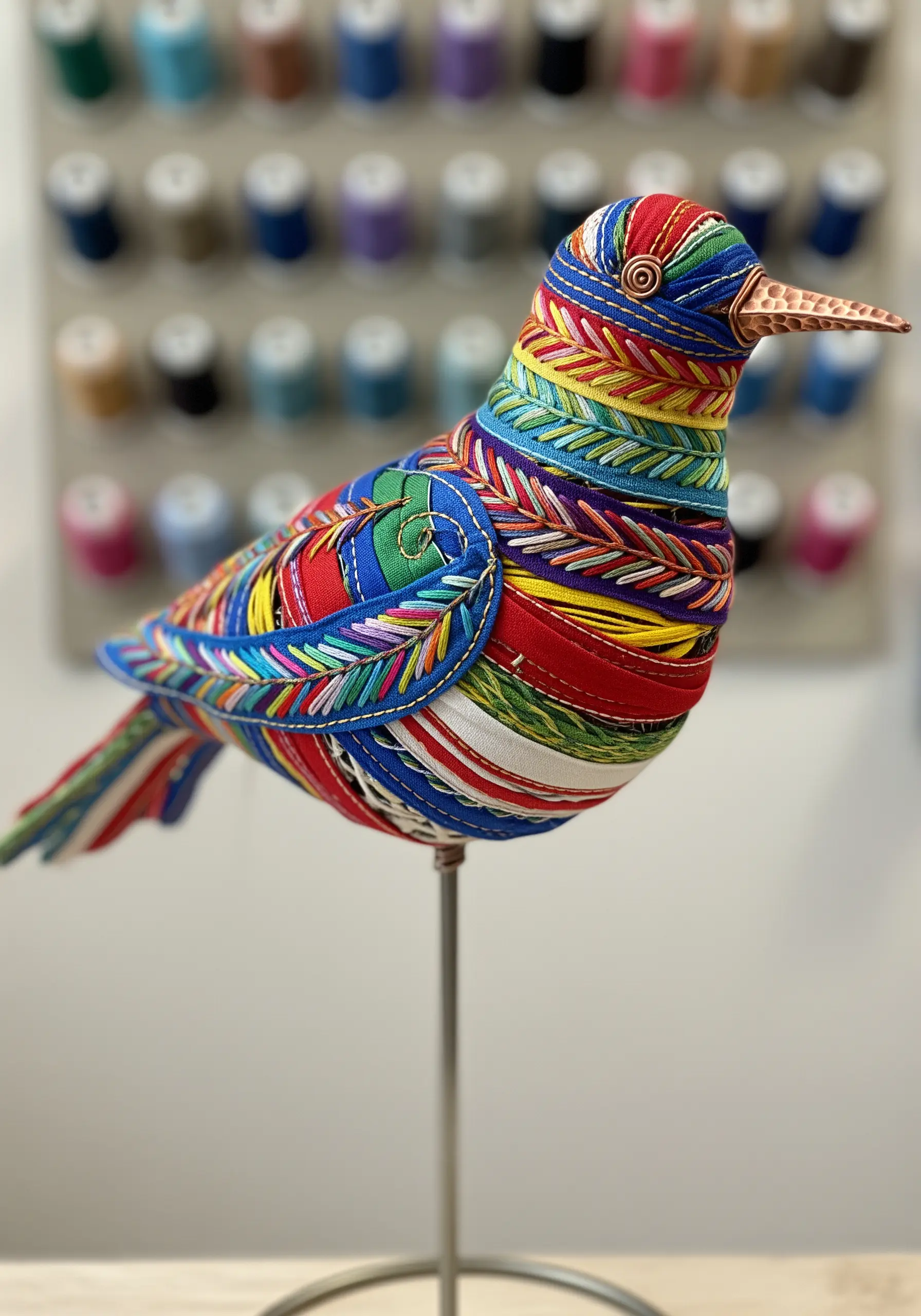 Bird sculpture wrapped in colorful embroidery thread
