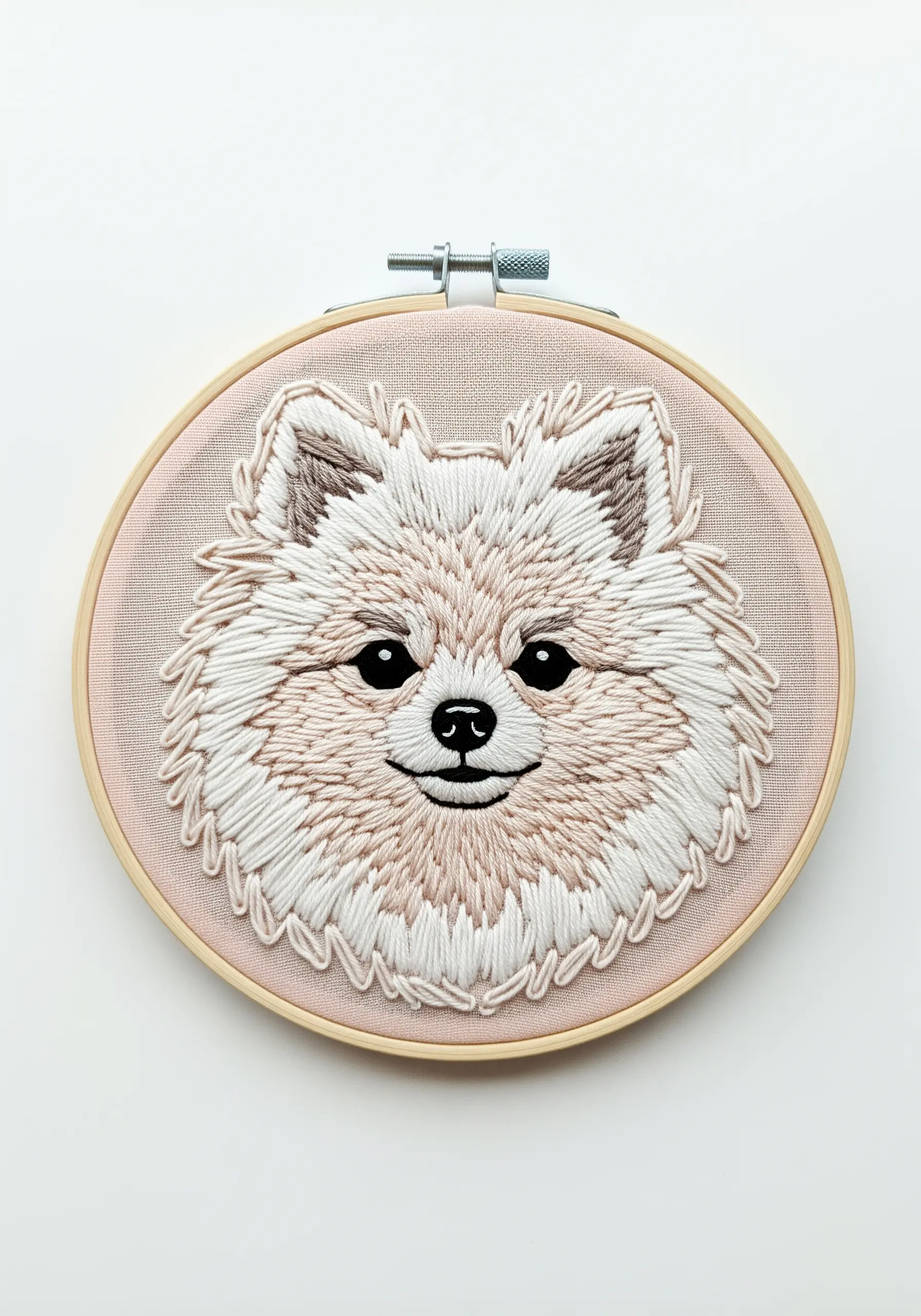 A highly textured, thread-painted portrait of a fluffy Pomeranian in a wooden hoop.