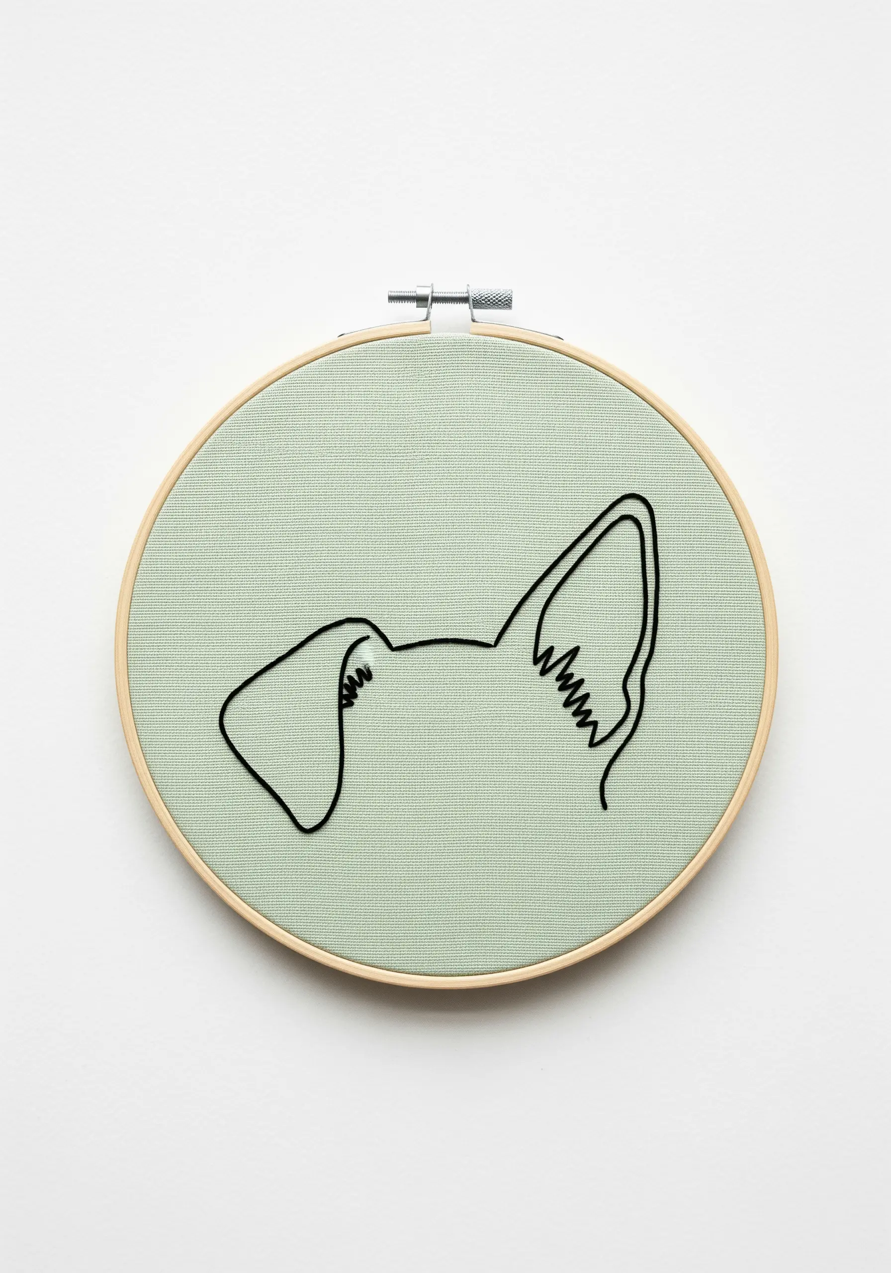 A minimalist embroidery showing only the outlines of two different dog ears side-by-side.