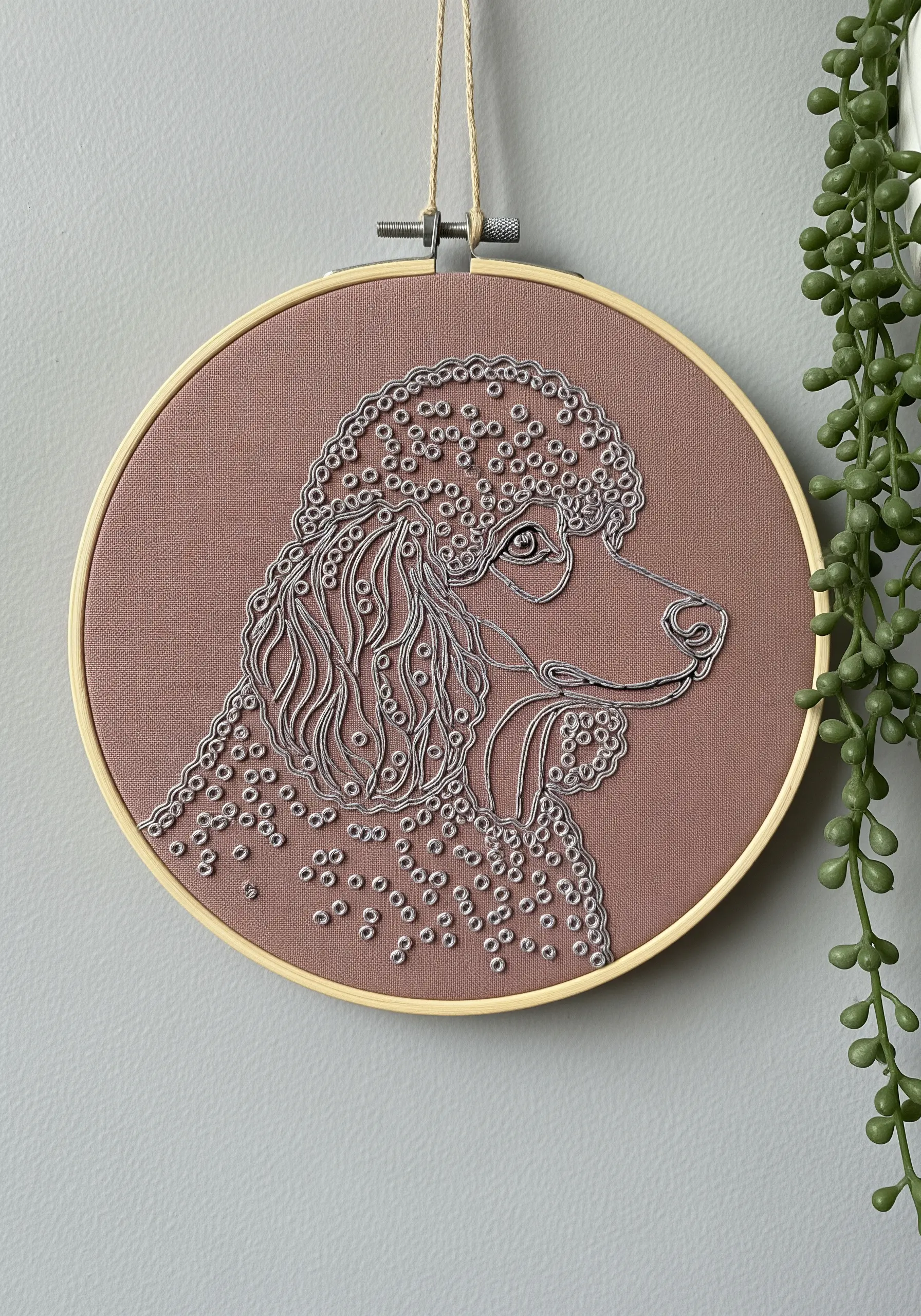 Poodle profile in silver thread, with curly fur created by hundreds of French knots.