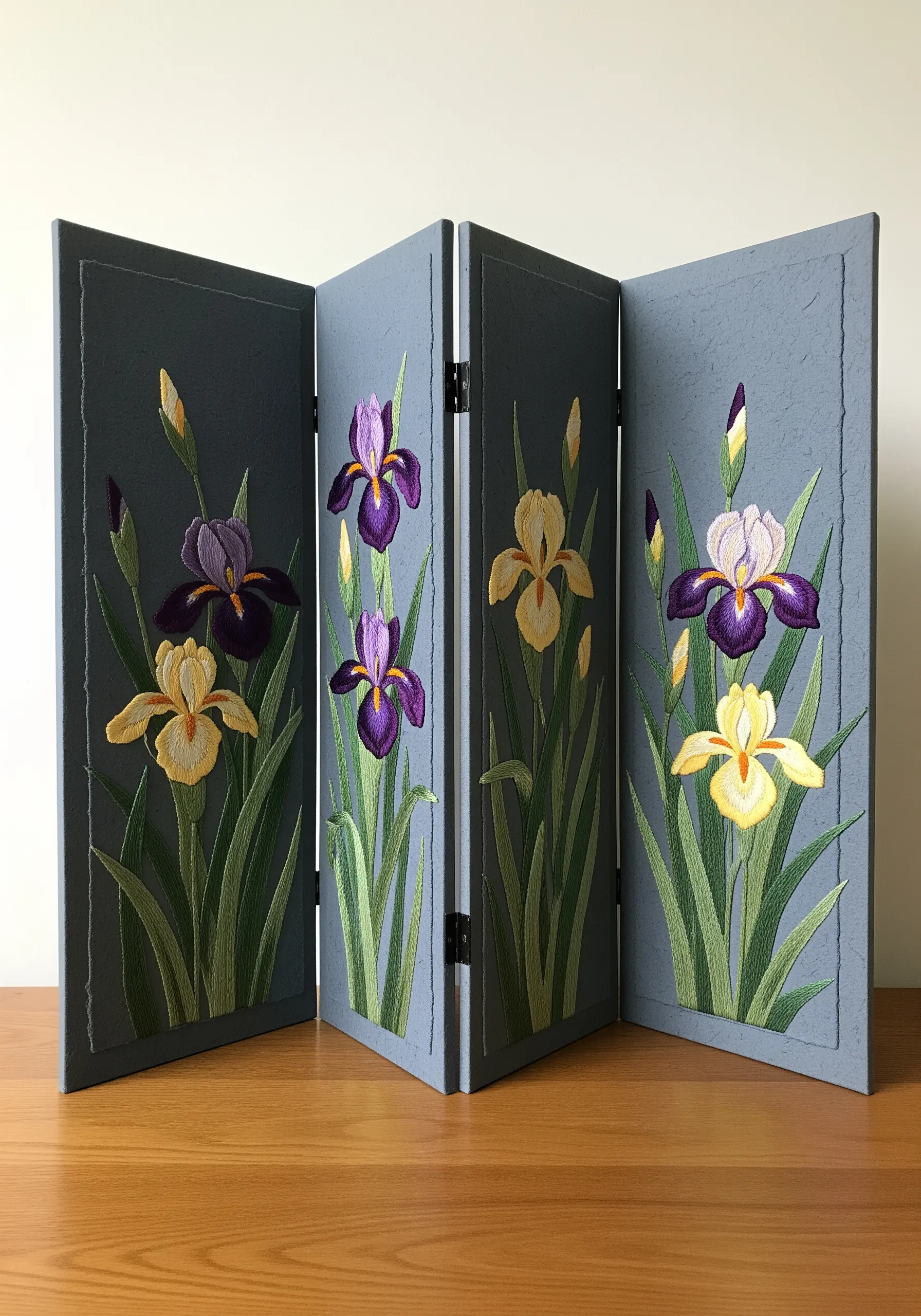A four-panel miniature folding screen, each panel featuring embroidered irises on blue paper.