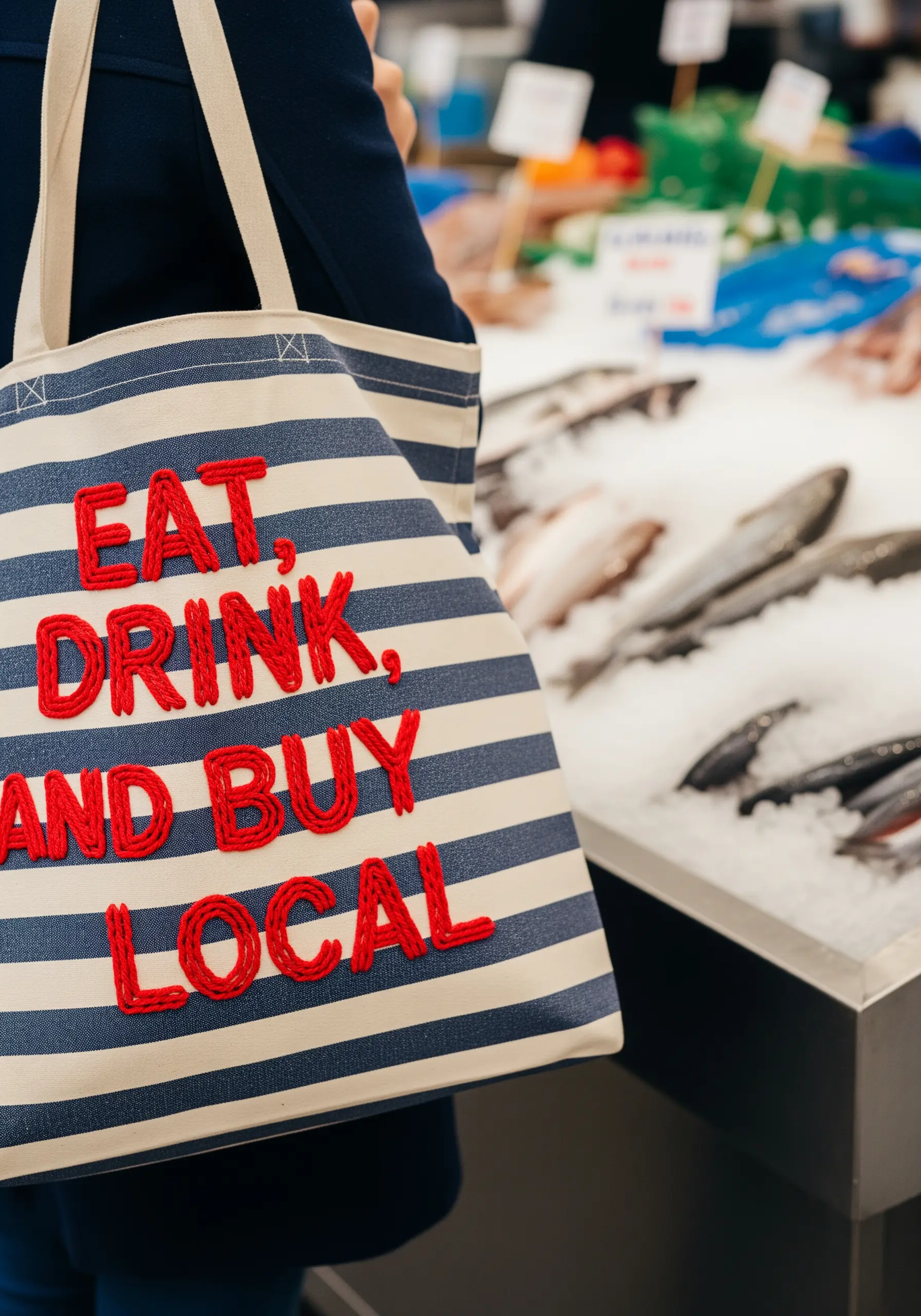 Striped tote bag with 'Eat, Drink, and Buy Local' in chunky, couched red yarn.