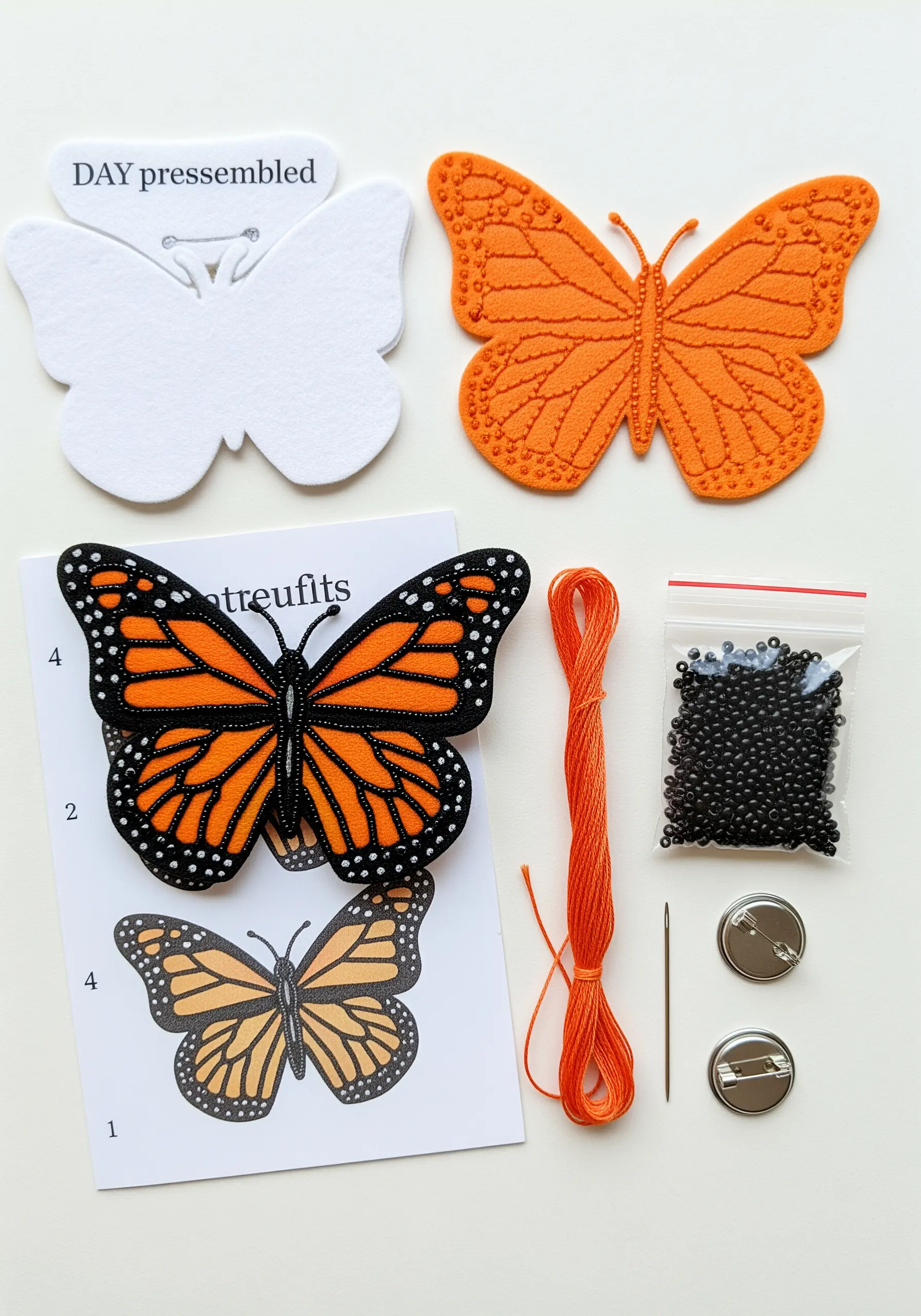 A DIY kit for making a monarch butterfly brooch from felt, thread, and beads.