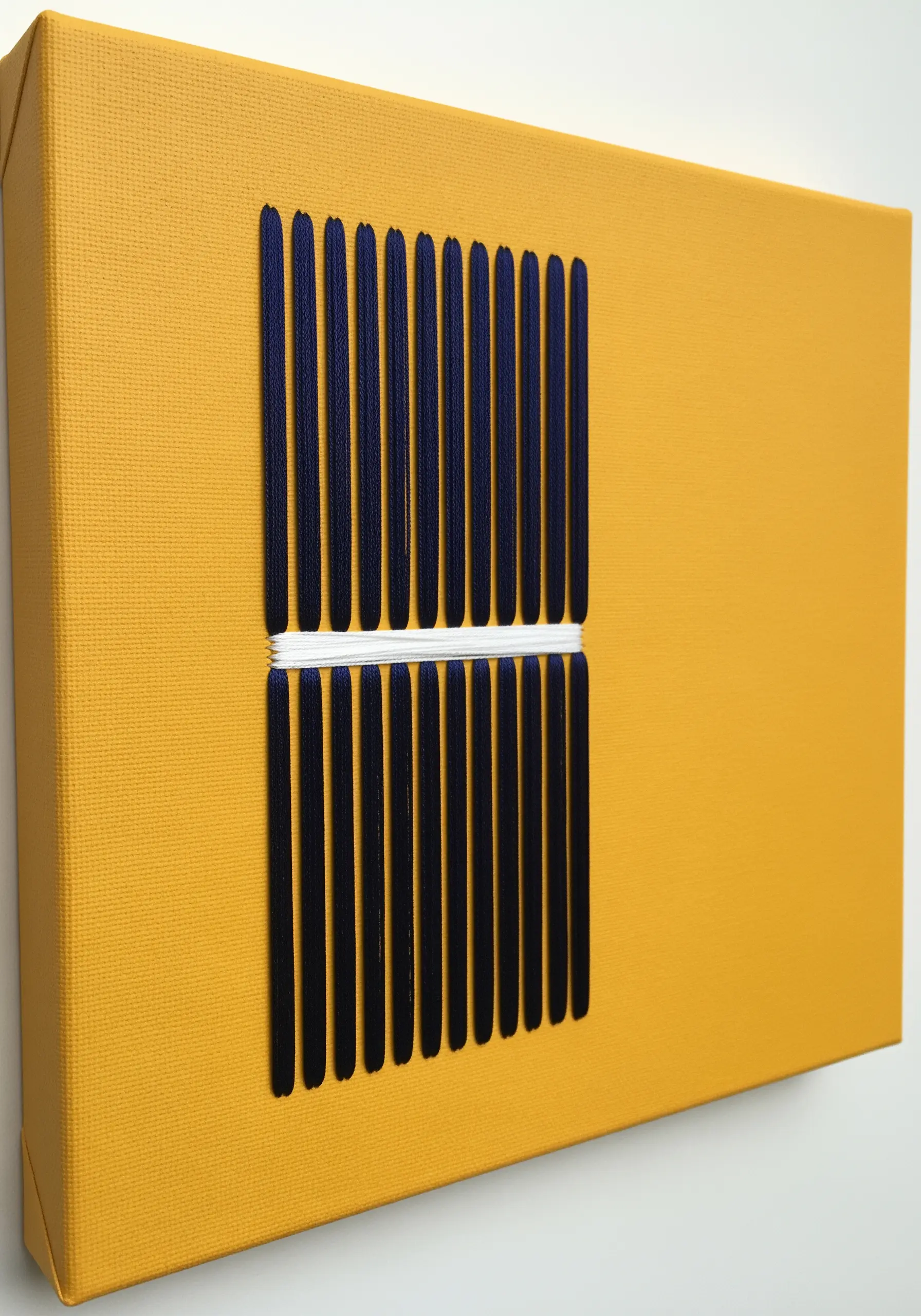 Vertical navy blue satin stitches on a yellow canvas, interrupted by a horizontal white band.