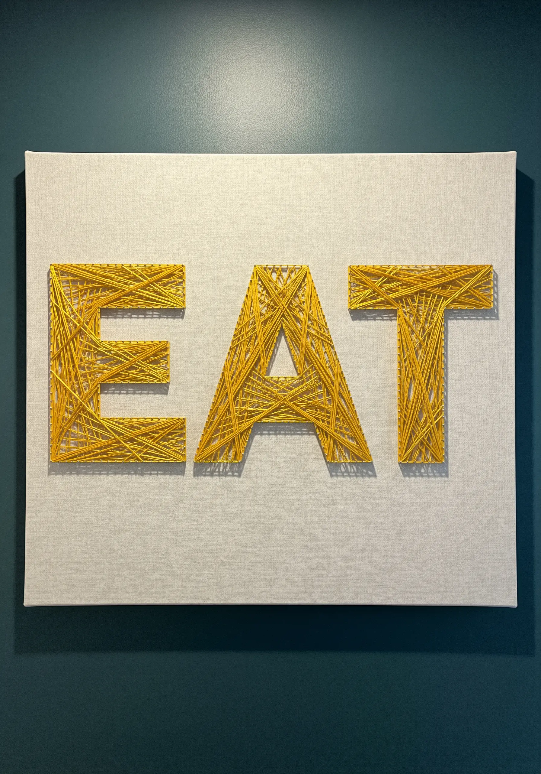 The word 'EAT' embroidered in yellow thread with dense, geometric straight stitch fills.