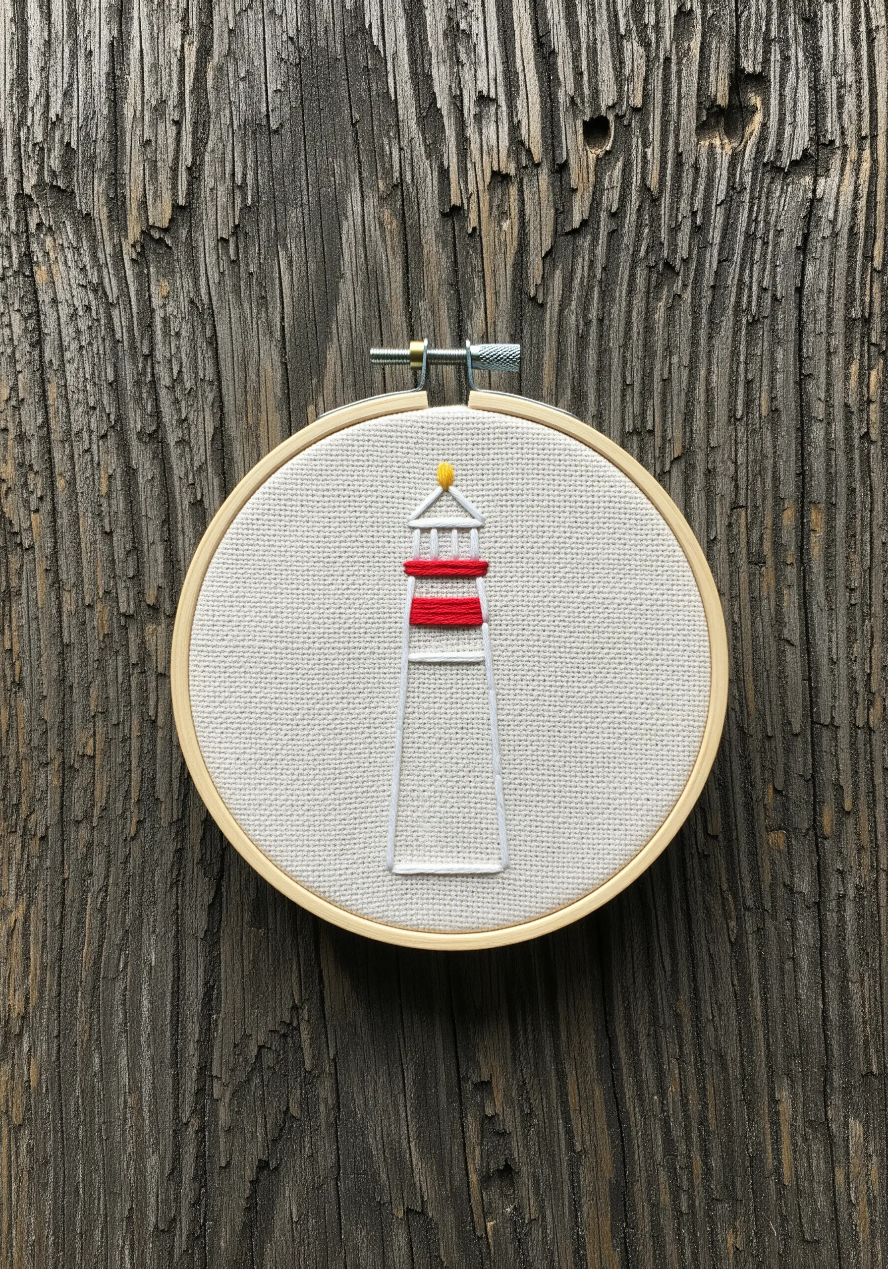A minimalist embroidered lighthouse with red and white stripes.