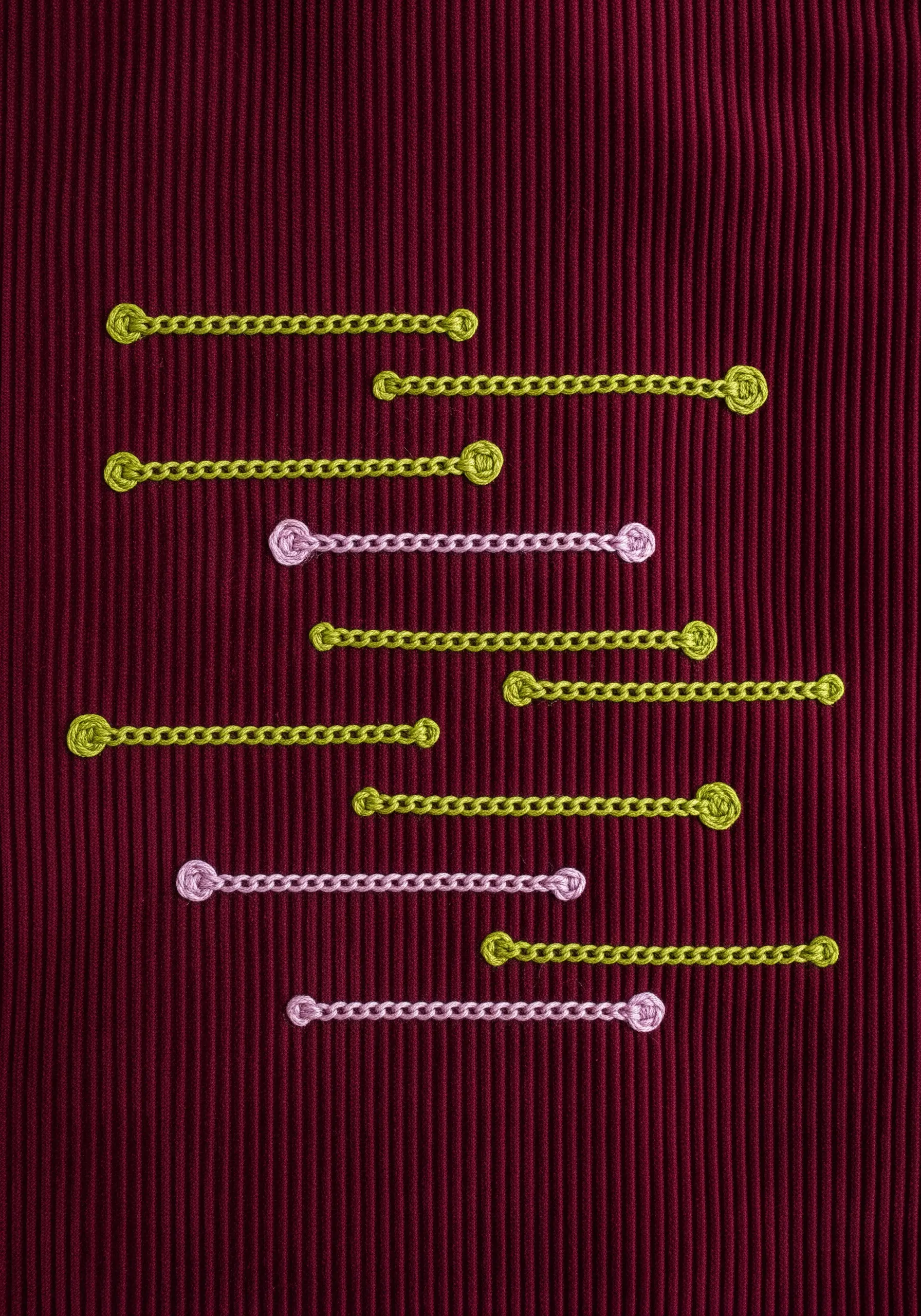 Yellow and pink chain stitches arranged horizontally on a deeply ribbed, dark red fabric.