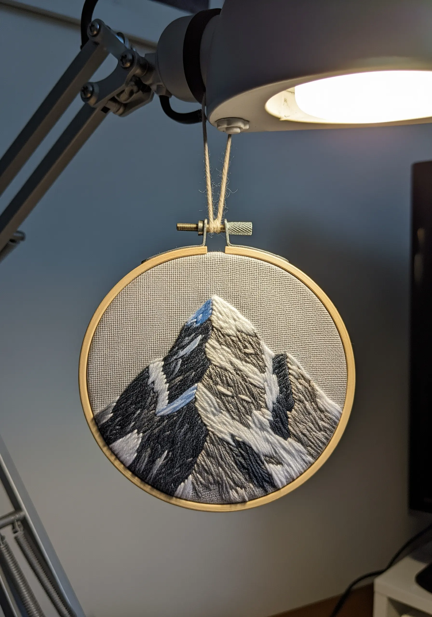 Detailed thread-painted mountain peak with shadows and highlights.