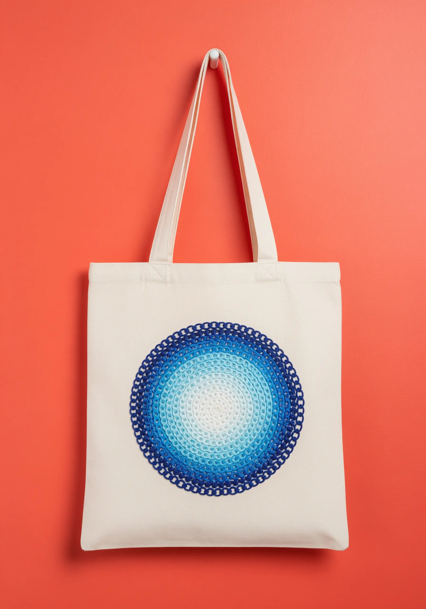 A circular blue-to-white gradient embroidered medallion on a canvas tote bag.