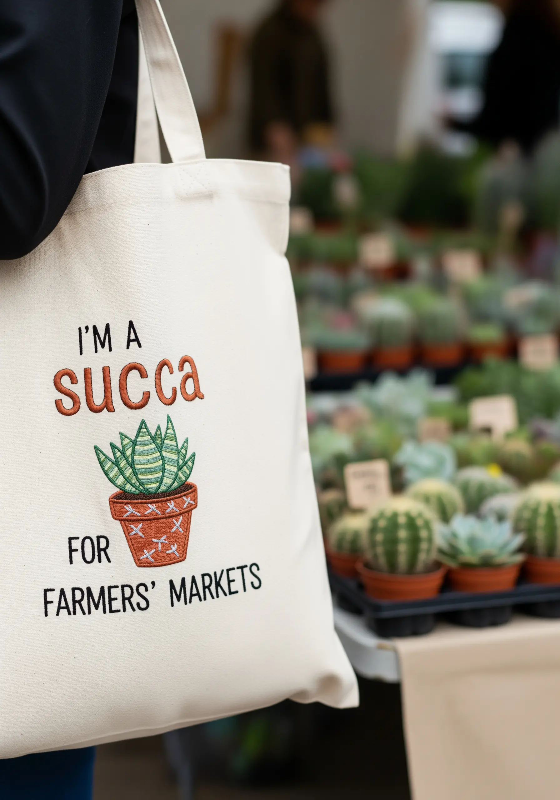 Canvas tote bag with a punny quote and a detailed embroidered succulent in a pot.