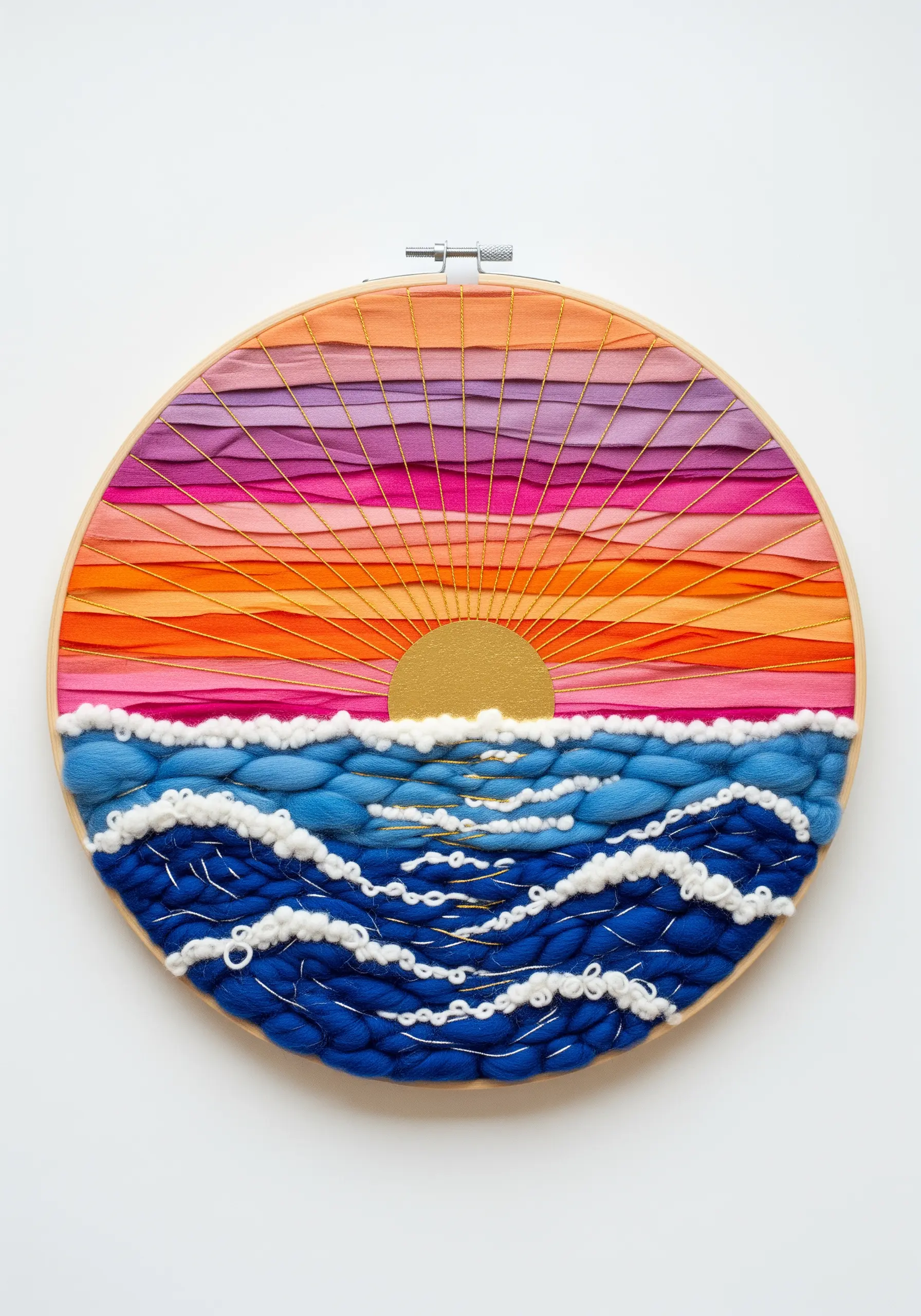 A woven sunset over the ocean in an embroidery hoop, with stitched sun rays and wave details.